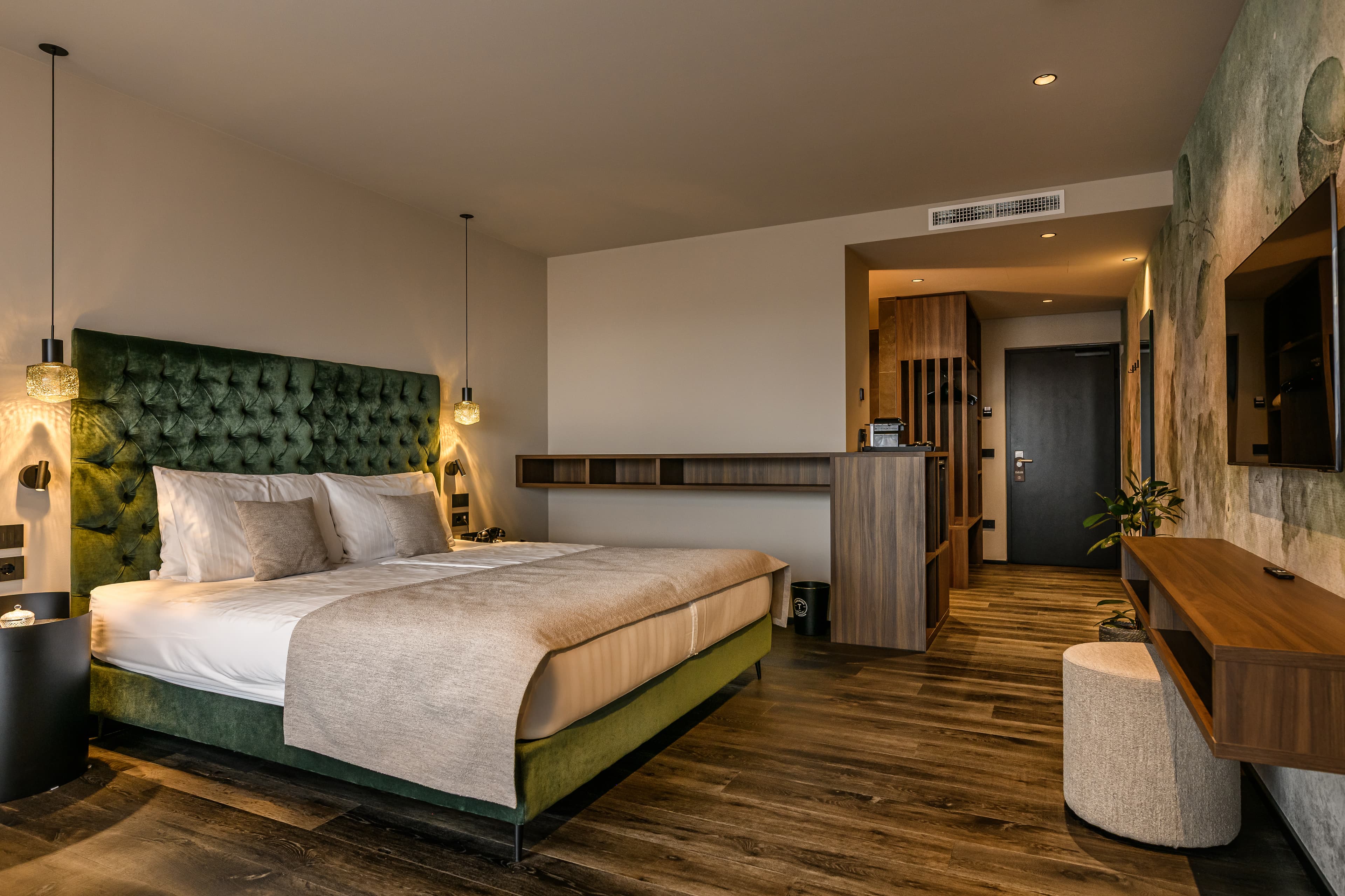 Bedroom with green headboard, wood paneling and stone accent wall - Hotel Tirolensis